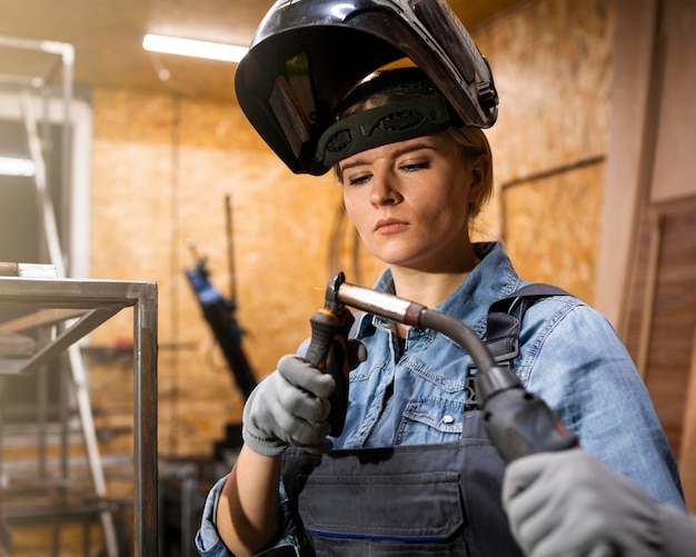 Front view of woman with welding tool