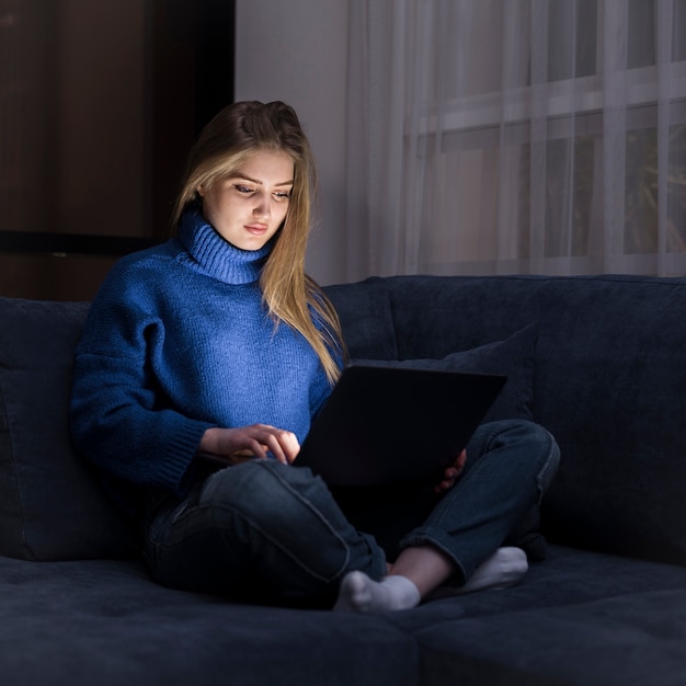 Front view of woman working on couch