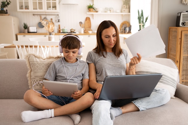 Free photo front view woman working from home with kid