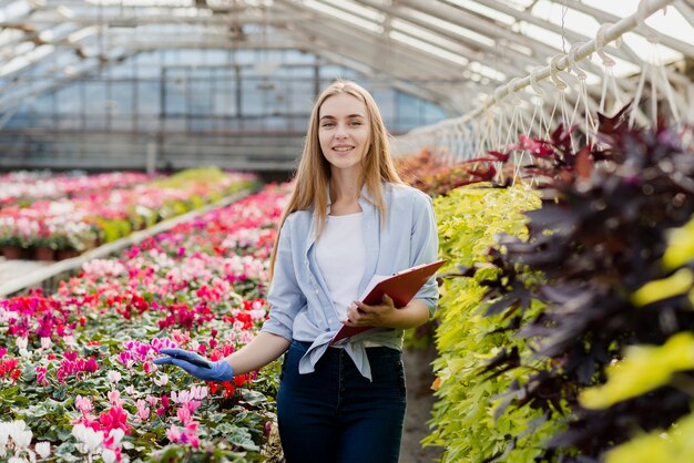 Front view woman working in greenhouse