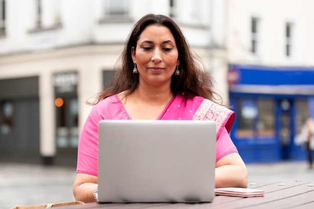 Вид спереди женщина работает на ноутбуке