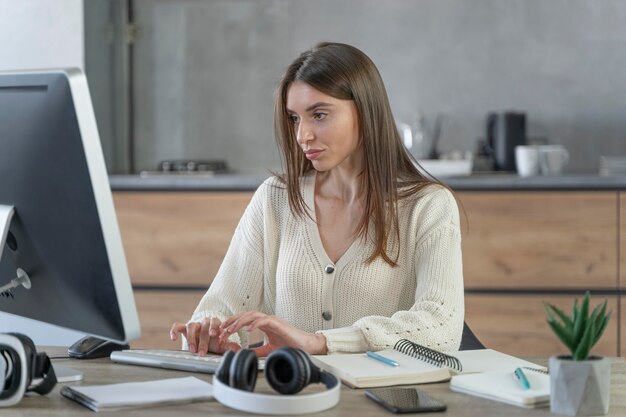 Вид спереди женщины, работающей в сфере средств массовой информации с персональным компьютером