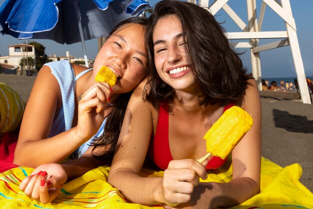 ビーチでアイスクリームを食べる女性の正面図