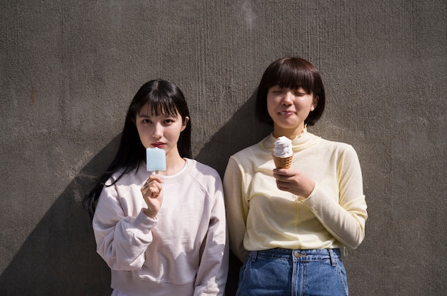 Free photo front view women eating ice cream together