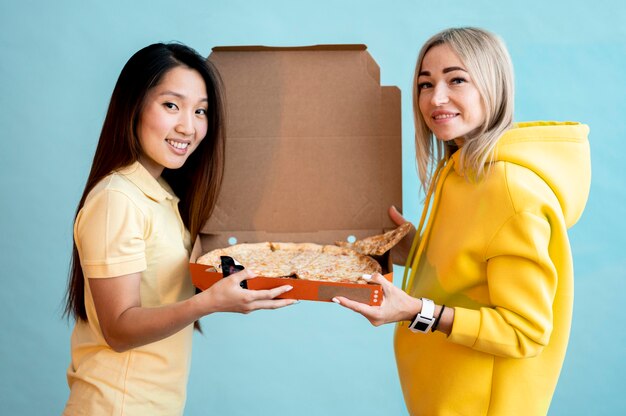 Front view women holding a box with pizza