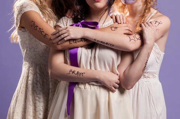 Front view of women hugging each other and holding ribbon