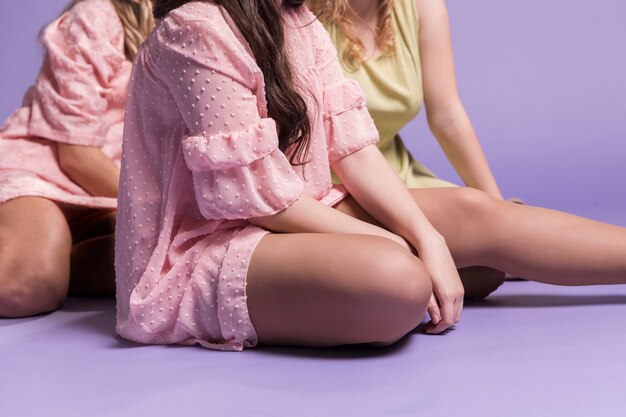 Front view of women posing while sitting on the floor