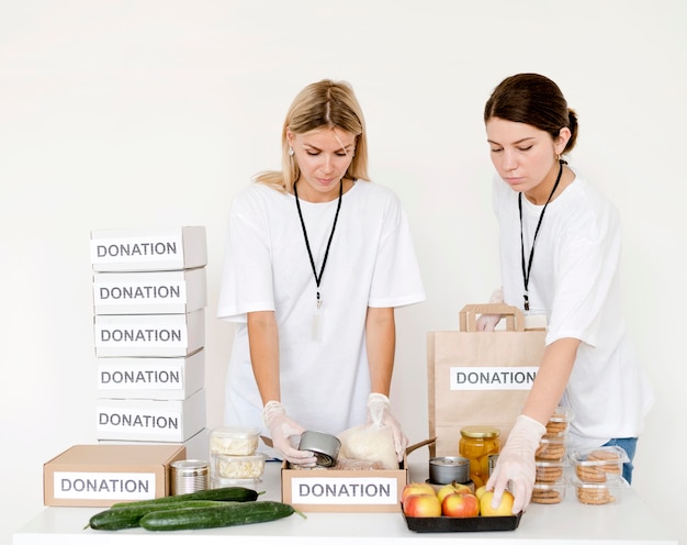 Front view of women preparing food for donation