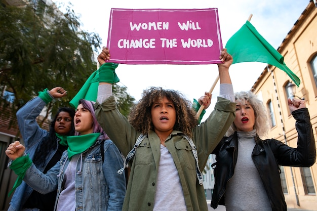 Бесплатное фото Женщины, вид спереди, протестуют на открытом воздухе