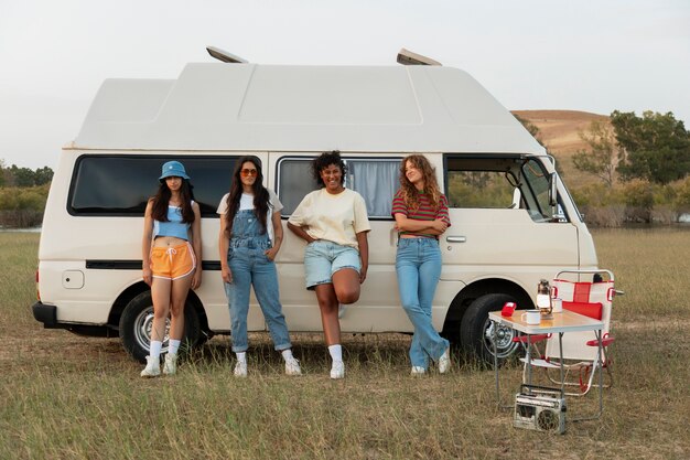 Front view women standing near campervan