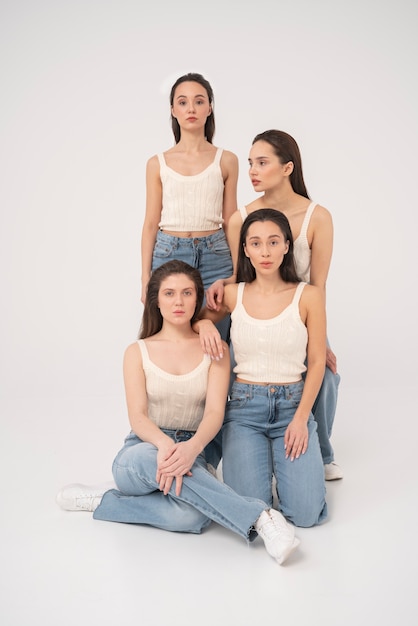 Foto gratuita vista frontale di donne in canotte e jeans che posano in ritratti minimalisti