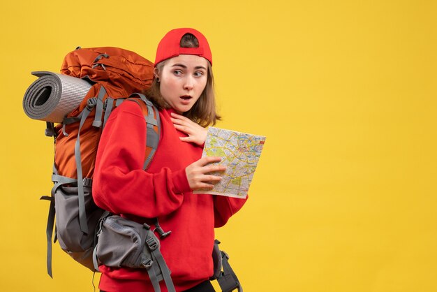 Front view wondered female hiker with red backpack holding map