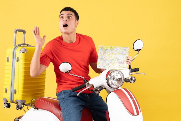 Front view wondered young man in casual clothes on moped holding travel map