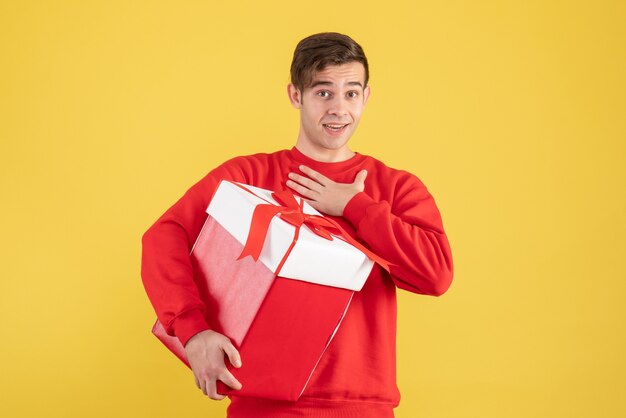 Front view wondered young man with red sweater standing on yellow 