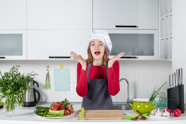 Front view wondered young woman in apron opening her hands