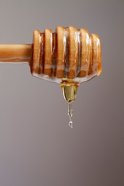 Front view of wooden honey dipper with honey