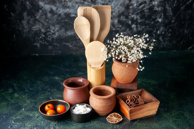 Front view wooden spoons with pots and cinnamon on dark table photo color seasoning salt cutlery