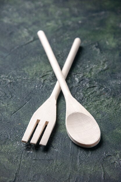 Front view wooden utensils on a dark background food dinner knife plastic kitchen fork spoon photo cutlery