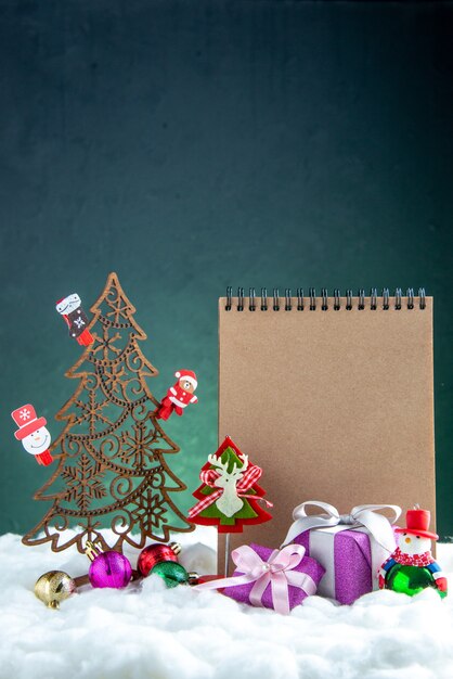 おもちゃの松ぼっくりノートブックの小さな贈り物と正面図木製のクリスマスツリー