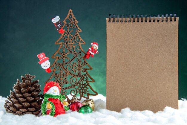 Free photo front view wooden xmas tree with toys pinecone notebook