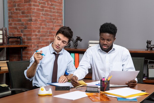 Front view work process two businessmen working in modern office