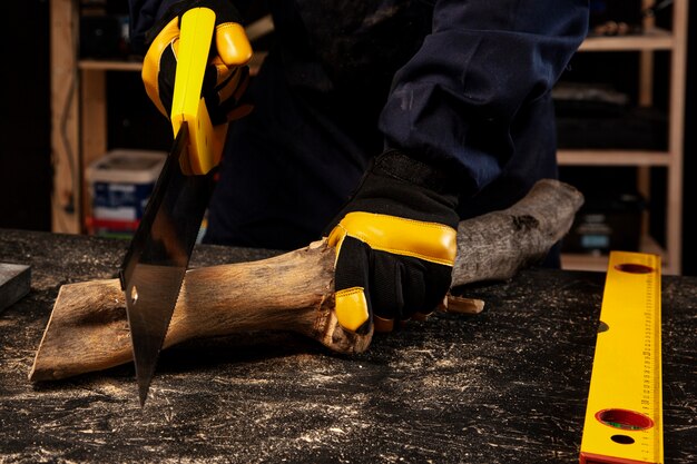 Lavoratore di vista frontale che taglia legno