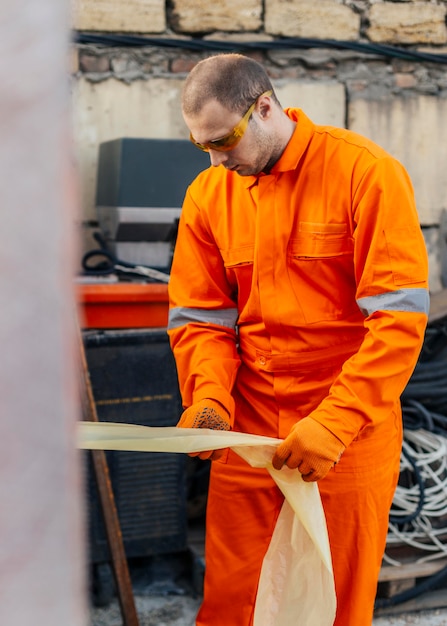 Foto gratuita vista frontale del lavoratore in uniforme con occhiali di sicurezza