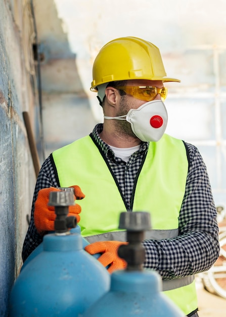 Front view of worker with protective mask and hard hat