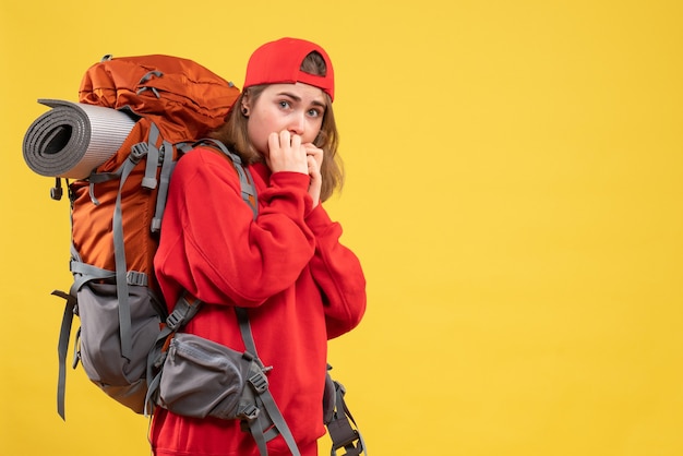 Foto gratuita vista frontale donna preoccupata viaggiatore in zaino rosso sulla parete gialla