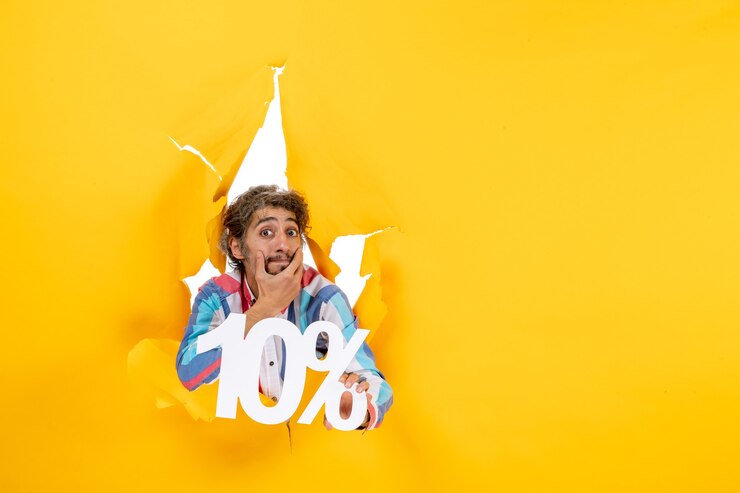 Free Photo front view of worried young man holding ten percentage thinking deeply in a torn hole in yellow paper
