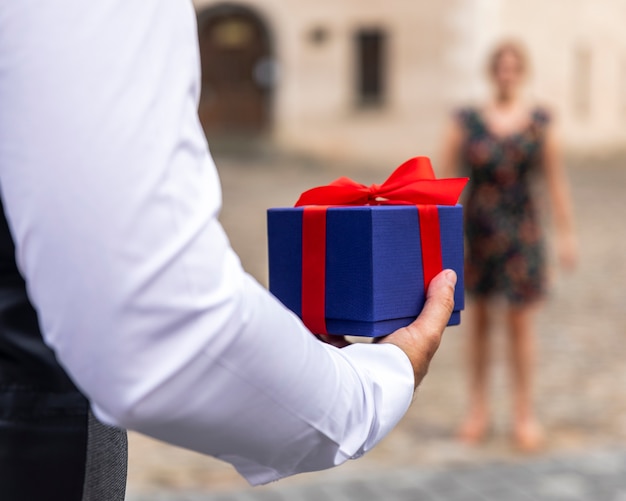 front view wrapped gift held by man