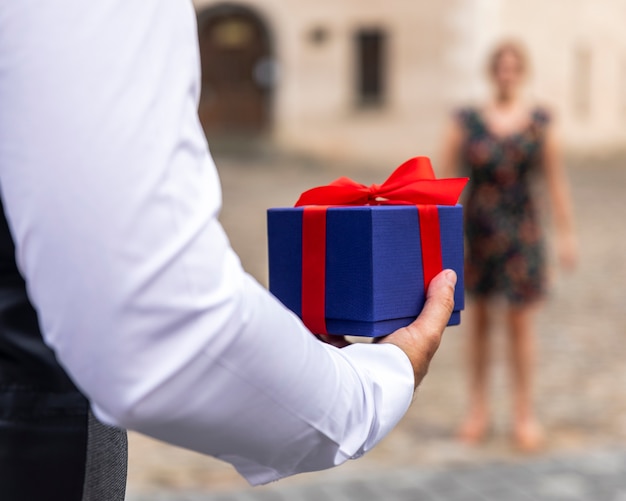 Front view wrapped gift held by man