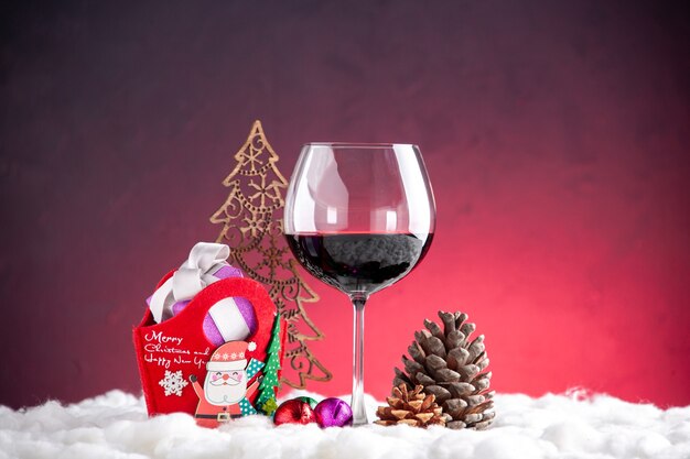 正面図クリスマスギフトおもちゃワイングラス松ぼっくり赤い背景