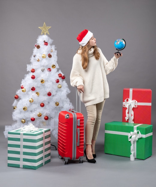 Donna di natale di vista frontale con il cappello della santa che esamina il globo