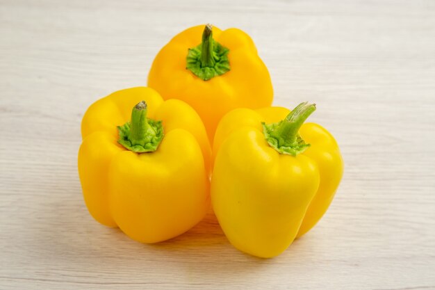 Front view yellow bell-peppers on white background salad tree ripe spicy color food meal photo