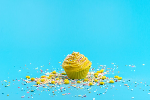 A front view yellow cake with colorful little candy particles on blue desk, cake sweet biscuit