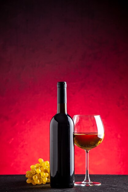 전면 보기 노란색 포도 와인 병 와인 빨간색 배경에 유리에
