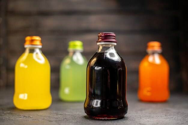 Front view yellow green black and orange fruit juice bottles