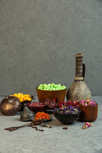 Free photo front view yellow and light green nogul candies with spices and dried flowers with a vase