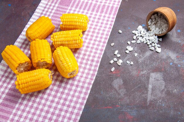 正面図黄色のスライスしたトウモロコシの生で新鮮な暗い表面のトウモロコシ植物食品生の新鮮