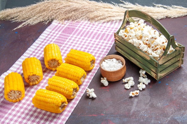 Front view yellow sliced corns raw and fresh with popcorn on a dark surface corn plant food raw fresh