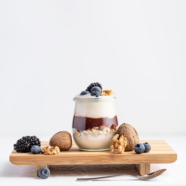Front view yogurt with jam and fruits on board
