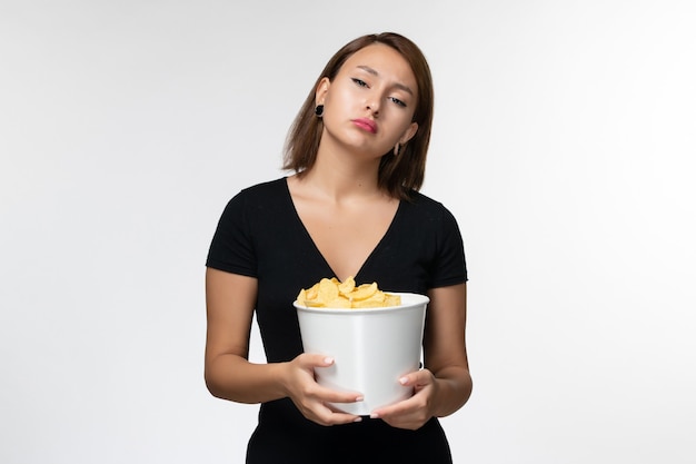 Front view young attractive female in black shirt holding basket with potato cips on white surface