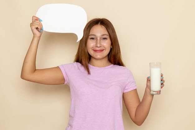 Front view young attractive female in pink t-shirt and blue jeans holding milk and sign