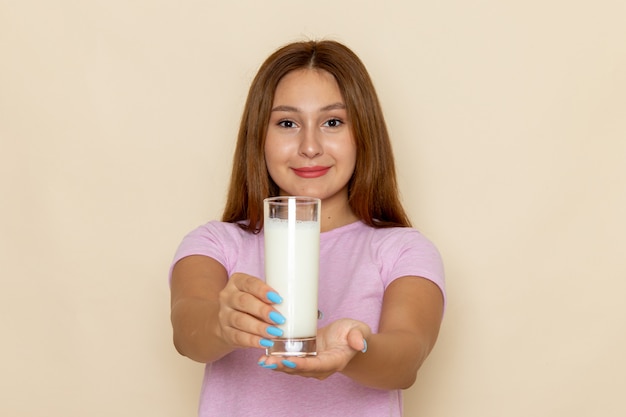 Free photo front view young attractive female in pink t-shirt and blue jeans holding milk