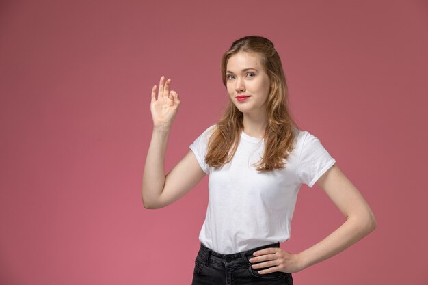 Front view young attractive female posing with smile on the pink wall model color female young