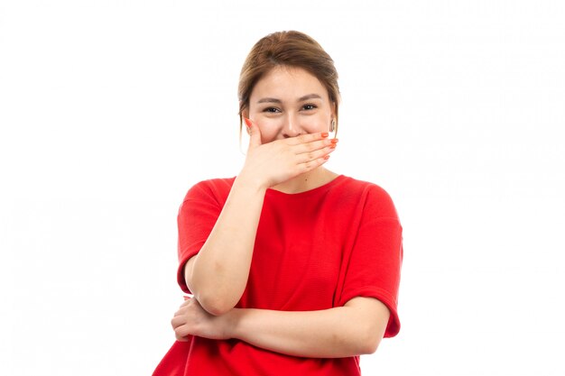 A front view young attractive girl in red t-shirt wearing black jeans laughing happy on the white