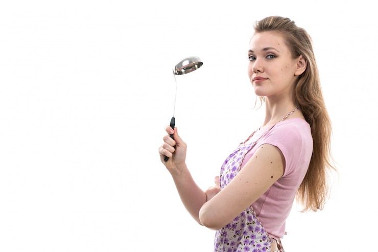 मुफ़्त फोटो a front view young attractive housewife in pink shirt colorful cape smiling posing holding appliance on the white background cuisine kitchen female