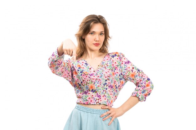 A front view young attractive lady in colorful flower designed shirt and blue skirt hand expression on the white