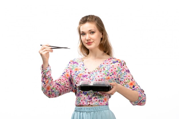 화려한 꽃의 전면 뷰 젊은 매력적인 아가씨는 셔츠와 흰색에 식사와 함께 막대기와 그릇을 들고 파란색 치마를 설계